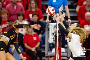 Nebraska Cornhusker Andi Jackson (15) and Bergen Reilly (2) jump to block Minnesota Golden Gopher Julia Hanson (22) in the third set during a college volleyball match Thursday, November 14, 2024, in Lincoln, Nebraska. Photo by John S. Peterson.