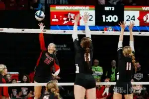 Norfolk Catholic's Mallory Wolf (10) spikes the ball against Yutan's Madison Wilson and Mckenna Jones during the NSAA State Volleyball Quarterfinals on November 6th, 2024 at Pinnacle Bank Arena in Lincoln, Nebraska. Photo by Mike Sautter.