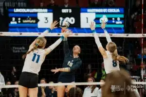 Lincoln Lutheran's Ava Jurevicius (10) spikes the ball against Hastings St. Cecilia's Payton Sullivan (11) and Brynn Weeks (8) during the NSAA State Volleyball Quarterfinals on November 6th, 2024 at Pinnacle Bank Arena in Lincoln, Nebraska. Photo by Mike Sautter.