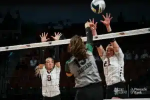 BDS's Alexis Hergott (9) and Campbell Bohling (21) jump up to block Howells-Dodge's Audrey Brabec (15) during the NSAA State Volleyball Quarterfinals on November 6th, 2024 at Pinnacle Bank Arena in Lincoln, Nebraska. Photo by Mike Sautter.