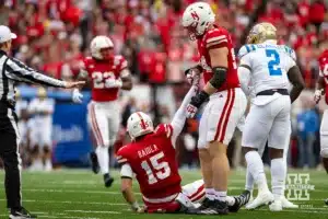 Nebraska Cornhusker offensive lineman Bryce Benhart (54) helps quarterback Dylan Raiola (15) get up after being tackled against the UCLA Bruins in the second quarter during a college football game Saturday, November 2, 2024, in Lincoln, Nebraska. Photo by John S. Peterson.