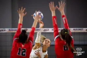 Creighton Bluejay outside hitter Ava Martin (8) spikes the ball against St. John's Red Storm outside hitter Giorgia Walther (12) and middle blocker Magda Stambrowska (8) in the second set during a college volleyball match Friday, November 1, 2024, in Omaha, Nebraska. Photo by John S. Peterson.