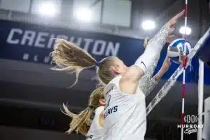 Creighton Bluejay setter Kendra Wait (15) jumps up to block the ball against the St. John's Red Storm during a college volleyball match Friday, November 1, 2024, in Omaha, Nebraska. Photo by John S. Peterson.