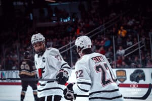 UNO Mavericks players, Alexi Van Houtte-Cachero and Jimmy Glynn, show appreciation during a college hockey game on Dec 29, 2024 in Omaha, Nebraska. Photo by Logan Hock