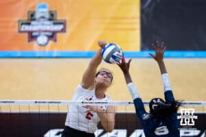 Nebraska Cornhuskers middle blocker Rebekah Allick (5) spikes the ball against Penn State Nittany Lions outside hitter Camryn Hannah (8) during the semi-final round in the NCAA championship Thursday, December 19, 2024, in Louisville, Kentucky. Photo by John S. Peterson.