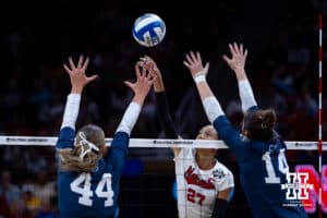 Nebraska Cornhuskers outside hitter Harper Murray (27) spikes the ball against Penn State Nittany Lions middle blocker Maggie Mendelson (44) and Caroline Jurevicius during the semi-final round in the NCAA championship Thursday, December 19, 2024, in Louisville, Kentucky. Photo by John S. Peterson.