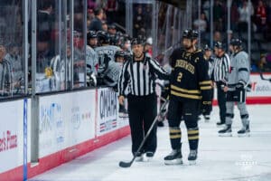 Player being brought to the pentalty box during a hockey match at Baxter Arena on Saturday, December 14, 2024, in Omaha, Nebraska. Photo by Collin Stilen.