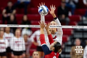 Nebraska Cornhuskers middle blocker Andi Jackson (15) jumps up to block Dayton Flyers setter Alyssa Miller (8) during the first regional match in the NCAA championship Friday, December 13, 2024, in Lincoln, Nebraska. Photo by John S. Peterson.