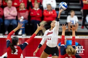 Nebraska Cornhuskers outside hitter Harper Murray (27) tips the ball over Dayton Flyers middle hitter Liana Sarkissian (12) and setter Ava Larkin (20) during the first regional match in the NCAA championship Friday, December 13, 2024, in Lincoln, Nebraska. Photo by John S. Peterson.