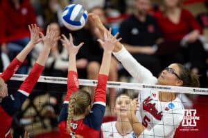 Nebraska Cornhuskers middle blocker Rebekah Allick (5) spikes the ball against Dayton Flyers outside hitter Brooke Smith (1) in the second set during the first regional match in the NCAA championship Friday, December 13, 2024, in Lincoln, Nebraska. Photo by John S. Peterson.