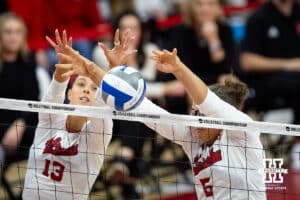 Nebraska Cornhuskers middle blocker Rebekah Allick (5) and Merritt Beason block a spike from the Dayton Flyers in the second set during the first regional match in the NCAA championship Friday, December 13, 2024, in Lincoln, Nebraska. Photo by John S. Peterson.