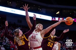 Nebraska Cornhuskers center Alexis Markowski (40) reaches for the balll against Minnesota Golden Gophers guard Grace Grocholski (25) and Minnesota Golden Gophers center Sophie Hart (52) during a college basketball game Sunday, December 8, 2024, in Lincoln, Nebraska. Photo by John S. Peterson.