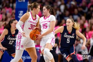 Creighton Bluejays guard Lauren Jensen (15) takes the hand off from Morgan Maly against UConn Huskies guard Paige Bueckers (5) in the second quarter during a college basketball game, Saturday, January 25, 2025, in Omaha, Nebraska. Photo by John S. Peterson.