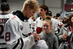 Omaha Maverick Marcus Broberg signs autographs for fan during a hockey match at Baxter Arena on Saturday, January 25, 2025, in Omaha, Nebraska. Photo by Collin Stilen.