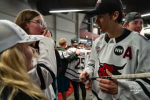 Omaha Maverick Harrison Israels signs autographs for fan during a hockey match at Baxter Arena on Saturday, January 25, 2025, in Omaha, Nebraska. Photo by Collin Stilen.