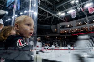 Omaha Maverick fan watches as the players zoom by during a hockey match at Baxter Arena on Saturday, January 25, 2025, in Omaha, Nebraska. Photo by Collin Stilen.