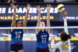 Omaha Supernovas Kayla Caffey (28) and Omaha Supernovas Lindsay Krause (22) jump to block a spike from San Diego Mojo Lauren Page (32) during a professional volleyball match, Sunday, January 19, 2025, in Omaha, Nebraska. Photo by John S. Peterson.