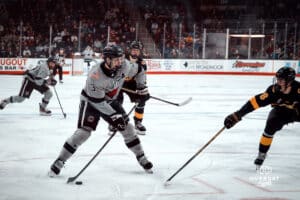 UNO Mavericks player, Sam Stange, looks for an open man during a college hockey game on Jan 11th, 2025 in Omaha, Nebraska. Photo by Logan Hock