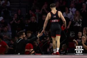 #16 Nebraska Cornhusker Lenny Pinto gives assistant coach Bryan Snyder five after the win against #24 Minnesota Golden Gopher Clayton Whiting during a college wrestling match, Saturday, January 11, 2025, in Lincoln, Nebraska. Pinto defeats Whiting 9-3. Photo by John S. Peterson.