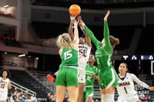 Omaha Mavericks Ja Harvey looks to shoot over two defenders during a college basketball game against North Dakota on January 2nd, 2025 in Omaha Nebraska. Photo by Brandon Tiedemann.
