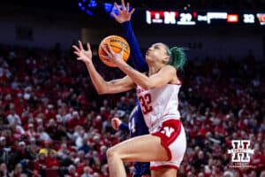 Nebraska Cornhusker forward Kendall Coley (32) makes a layup against Washington Huskies guard Elle Ladine (24) in the second quarter during a college women’s basketball game Sunday, February 23, 2025 in Lincoln, Nebraska. Photo by John S. Peterson.