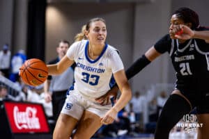 Creighton Bluejay guard Brooke Littrell (33) drives to the lane against Georgetown Hoya center Ariel Jenkins (21) in the second quarter during a college basketball game Saturday, February 15, 2025 in Omaha, Nebraska. Photo by John S. Peterson.