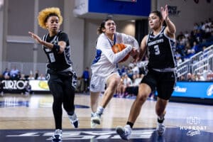 Creighton Bluejay guard Kiani Lockett (11) drives to the basket against Georgetown Hoya guard Victoria Rivera (3) and Khadee Hession in the second half during a college basketball game Saturday, February 15, 2025 in Omaha, Nebraska. Photo by John S. Peterson.