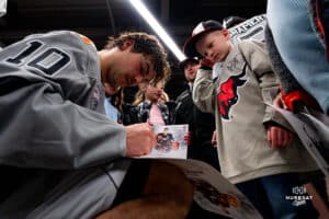 Omaha Maverick Jacob Guevin signing autographs for the young fans during a hockey match at Baxter Arena on Saturday, February 2, 2025, in Omaha, Nebraska. Photo by Collin Stilen.