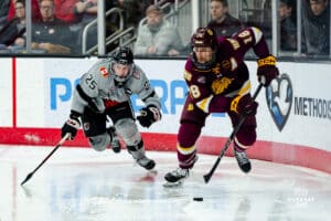 Omaha Maverick Cam Mitchell in the race for the puck during a hockey match at Baxter Arena on Saturday, February 2, 2025, in Omaha, Nebraska. Photo by Collin Stilen.