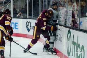 Omaha Maverick Sam Stange gets pinned to the wall while both players battle for the puck during a hockey match at Baxter Arena on Saturday, February 2, 2025, in Omaha, Nebraska. Photo by Collin Stilen.