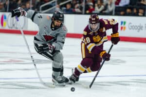 Omaha Maverick Charlie Lurie battles for the puck during a hockey match at Baxter Arena on Saturday, February 2, 2025, in Omaha, Nebraska. Photo by Collin Stilen.