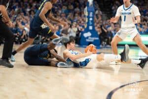 Creighton Bluejays Mason Miller dives for a loose ball during a college basketball game against Marquette on February 8th, 2025 in Omaha, Nebraska. Photo by Brandon Tiedemann.