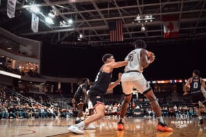 UNO Mavericks player, Isaac Ondekane, posting up against a Denver opponent during a college basketball game on Feb 01, 2025 in Omaha, Nebraska. Photo by Logan Hock