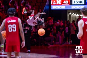 Nebraska football player Jeremiah Charles does a twisting flip as he comes for the football team dunk contest at halftime during a college basketball game against the Illinois Fighting Illini, Thursday, January 30, 2025, in Lincoln, Nebraska. Photo by John S. Peterson.