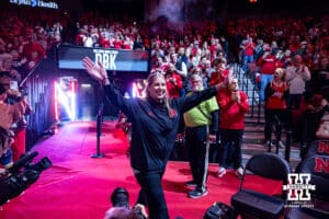 Incoming head volleyball coach Dani Busboom-Kelly walks out on to the court to meet coach John Cook in a passing of the touch during a college basketball game against the Illinois Fighting Illini, Thursday, January 30, 2025, in Lincoln, Nebraska. Photo by John S. Peterson.