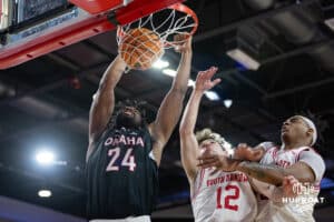 Omaha Mavericks center Isaac Ondekane (24) makes a dunk against South Dakota Coyotes guard Isaac Bruns (12) and forward Ashton Smith (32) in the second half during a college basketball game, Wednesday, January 29, 2025, in Vermillion, South Dakota. Photo by John S. Peterson.