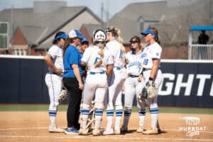 Creighton Bluejays meet during a college softball game against UCONN on March 28th, 2025 in Omaha, Nebraska. Photo by Brandon Tiedemann.