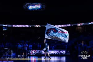 Omaha Supernovas spirit squad member waves the flag for introductions before the game against the Vegas Thrill during a professional volleyball match Friday, March 28, 2025 in Omaha, Nebraska. Photo by John S. Peterson.