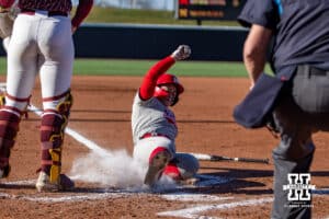 Nebraska Cornhusker Olivia DiNardo (1) scores on an error against Minnesota Golden Gopher Taylor Krapf (13) in the first inning during a college softball game Friday, March 21, 2025 in Lincoln, Nebraska. Photo by John S. Peterson.