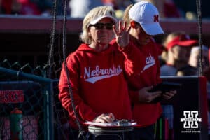 Nebraska Cornhusker head coach Rhonda Revelle gives a signal to catcher Ava Bredwell against the Minnesota Golden Gophers during a college softball game Friday, March 21, 2025 in Lincoln, Nebraska. Photo by John S. Peterson.