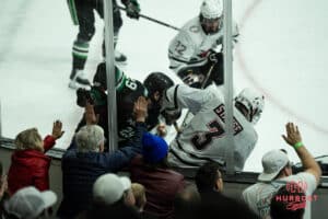 Omaha Mavericks fans smack the glass during a college hockey game against North Dakota on March 15th, 2025 in Omaha Nebraska. Photo by Brandon Tiedemann.