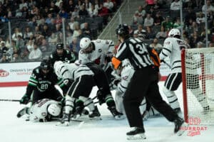Omaha Mavericks fight for the puck during a college hockey game against North Dakota on March 15th, 2025 in Omaha Nebraska. Photo by Brandon Tiedemann.