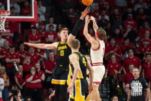 Nebraska Basketball player Sam Hoiberg shoots over Iowa opponent, Even Brauns, during a college basketball game on March 09, 2025 in Lincoln, Nebraska. Photo by Logan Hock.