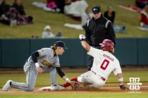 Nebraska Cornhusker Cayden Brumbaugh (0) steals third base against during a college baseball game Tuesday, March 11, 2025 in Lincoln, Nebraska. Photo by John S. Peterson.