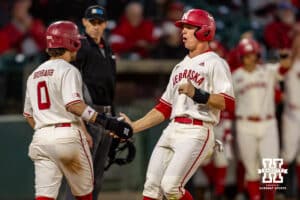 Nebraska Cornhuskers Cayden Brumbaugh (0) and Cael Frost (12) scoring in the fifth against the Wichita St. Shockers during a college baseball game Tuesday, March 11, 2025 in Lincoln, Nebraska. Photo by John S. Peterson.