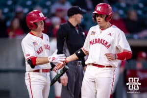 Nebraska Cornhusker Case Sanderson (14), on the right, scores getting five from Cael Frost (12) at home against the Wichita St. Shockers in the fifth inning during a college baseball game Tuesday, March 11, 2025 in Lincoln, Nebraska. Photo by John S. Peterson.