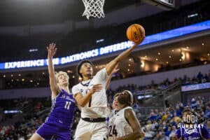 Omaha Maverick guard Lance Waddles (7) makes a layup against St. Thomas Tommies guard Drake Dobbs (11) in the first half during the Summit League Tournament Finals Sunday, March 9, 2025 in Sioux Falls, South Dakota. Photo by John S. Peterson.