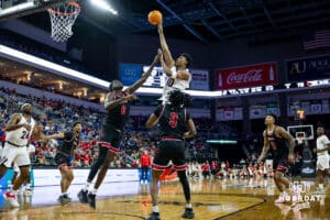 Nebraska-Omaha Maverick guard Lance Waddles (7) makes a little jump shot against South Dakota Coyote forward Mayuom Buom (0) in the second half during the Summit League Tournament Saturday, March 8, 2025 in Sioux Falls, South Dakota. Photo by John S. Peterson.