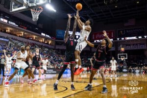Nebraska-Omaha Maverick forward Marquel Sutton (10) makes a basket over South Dakota Coyote forward Mayuom Buom (0) in the second half during the Summit League Tournament Saturday, March 8, 2025 in Sioux Falls, South Dakota. Photo by John S. Peterson.