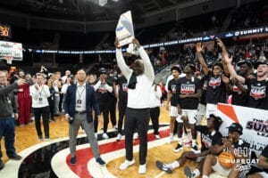 Omaha Mavericks Coach Crutchfield hoists the regular season trophy during a college basketball game against Oral Roberts on March 1st, 2025 in Omaha Nebraska. Photo by Brandon Tiedemann.